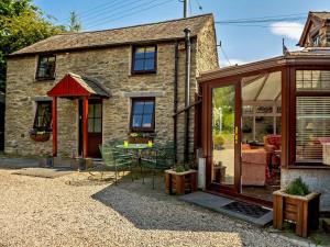 a stone house with a table in front of it at 2 Bed in Colwyn Bay oc-50933 in Eglwys-Fâch