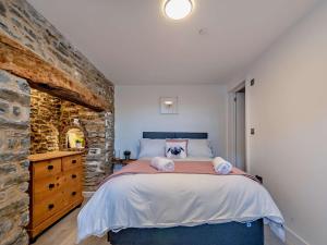 a bedroom with a large bed and a stone wall at 4 Bed in Llandovery oc-90307 in Myddfai