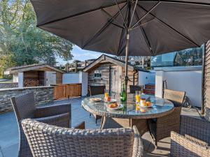 a patio with a table and chairs with an umbrella at 4 Bed in Llandovery oc-90307 in Myddfai