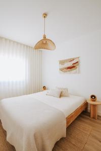 a bedroom with a bed and a pendant light at Casa D'Almo in Almograve
