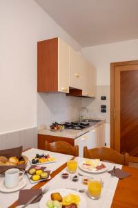 a kitchen with a table with plates of food on it at Olimpia Hotel & Aparthotel in Bibione