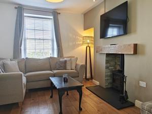 a living room with a couch and a fireplace at 3 Bed in Aberaeron oc-95971 in Aberaeron