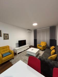a living room with a couch and chairs and a tv at Ana Lux Master Apartment 14 in Podgorica