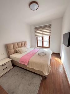 a bedroom with a large bed and a window at Ana Lux Master Apartment 14 in Podgorica