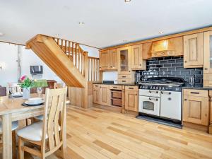 a kitchen with wooden cabinets and a white stove top oven at 1 Bed in Narberth oc-72867 in Whitland