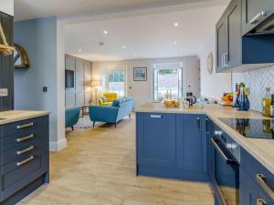 a kitchen with blue cabinets and a living room at 3 Bed in New Quay oc-83998 in New Quay