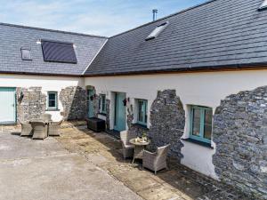 a building with a patio with chairs and a table at 1 Bed in Narberth oc-72867 in Whitland