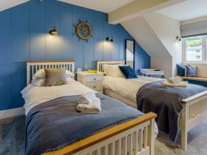 two beds in a room with blue walls at 3 Bed in New Quay oc-83998 in New Quay