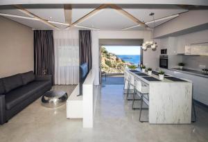 a kitchen and living room with a couch and a table at Aquamarine Luxury Suites - Stegna - Beachfront, Jacuzzi , Smart Home, Great View in Archangelos
