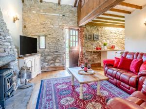 a living room with a red couch and a fireplace at 1 Bed in Swansea oc-77981 in Penclawdd