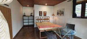 a bedroom with a bed and a glass table at wild grove resorts in Varagampadi