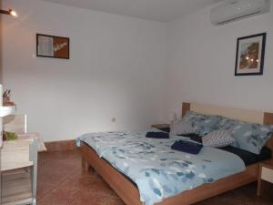 a bedroom with a bed with a blue comforter at Guest House Tiho in Silba