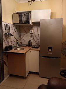 a small kitchen with a refrigerator and a sink at Naliya Guest house in Cape Town