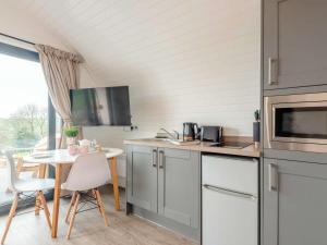 a kitchen with white cabinets and a table with chairs at 1 Bed in Corwen oc-80320 in Gwyddelwern