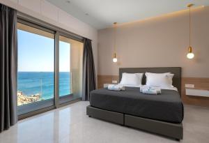 a bedroom with a bed with a view of the ocean at Aquamarine Luxury Suites - Stegna - Beachfront, Jacuzzi , Smart Home, Great View in Archangelos +42 photos