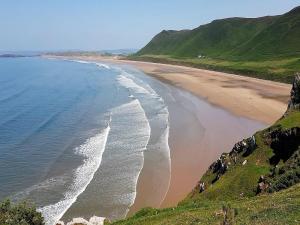 an aerial view of a beach with the ocean at 1 Bed in Swansea oc-74221 in Ilston
