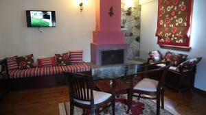a living room with a table and a fireplace at Giagia Evgenia in Vitsa