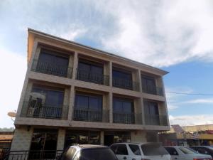 a building with cars parked in front of it at Hotel Shine Sunet in Mbarara