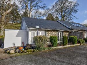 a small stone house with a white garage at 2 Bed in Bala oc-86964 in Llandderfel