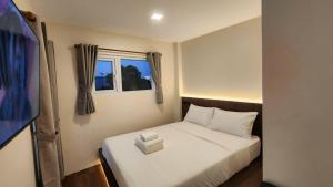 a bedroom with a white bed with a window at Old City Hall, Contactless Check In in Bangkok