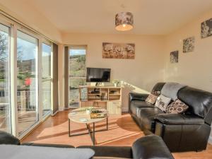 a living room with a leather couch and a table at 2 Bed in Bala oc-86964 in Llandderfel