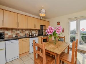 a kitchen with a wooden table with pink flowers on it at 2 Bed in Bala oc-86964 in Llandderfel +6 photos
