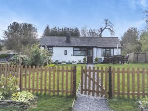 a white house with a fence in the yard at 2 Bed in Mold oc-90461 in Caerwys