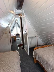 an attic room with two beds and an open door at Zawojskie Spanie in Zawoja +47 photos