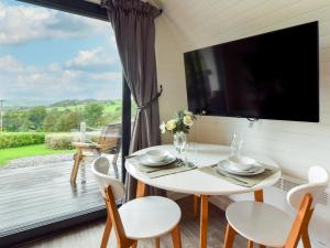 a dining room with a table and chairs and a large window at 1 Bed in Corwen oc-80321 in Gwyddelwern