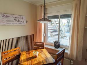 a dining room table with chairs and a window at Ferienwohnung Seerose mit Terrasse in Sassnitz +12 photos