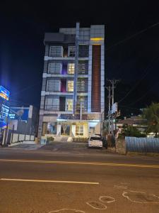 a tall building with a car parked in front of it at Miracle Hotel Manado in Manado