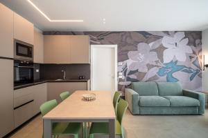 a kitchen and living room with a table and a couch at A&G green flat il mare e Venezia in Cavallino-Treporti