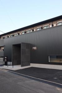 a black building with a large open garage at stella stay in Imari
