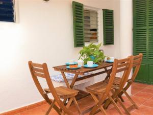 a wooden table with two chairs and a table with a plant at Cas Bufador in Sa Coma