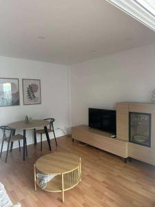 a living room with a table and a television at Sea & Mountain Views Benicassim in Benicàssim