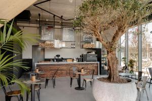 a restaurant with tables and chairs and a tree at Makerstoren Short stay serviced apartments for 28 to 180 days in Amsterdam