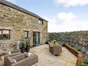 a patio with furniture and a stone building at 2 Bed in Amlwch oc-77640 in Llanfechell