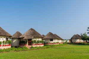 a row of cottages with thatched roofs at Forest Mud Villas in Haridwār