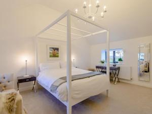a bedroom with a white canopy bed and a table at 2 Bed in Amlwch oc-77640 in Llanfechell