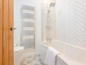 a white bathroom with a tub and a toilet at 2 Bed in Amlwch oc-77640 in Llanfechell +20 photos