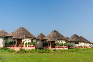 a row of hacienda style houses with thatched roofs at Forest Mud Villas in Haridwār +2 photos
