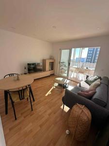 a living room with a couch and a table at Sea & Mountain Views Benicassim in Benicàssim