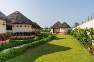 a row of hacienda style houses with grass at Forest Mud Villas in Haridwār
