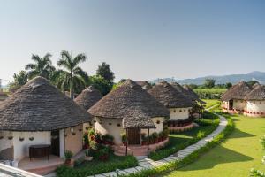 a row of houses with thatched roofs at Forest Mud Villas in Haridwār