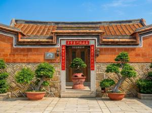 a building with potted plants in front of a door at Zhong Lan Homestay in Chung-lan
