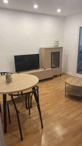 a living room with a table and a tv at Sea & Mountain Views Benicassim in Benicàssim
