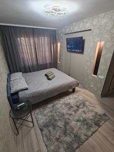 a bedroom with a bed and a rug at Agnes Apartament in Valmiera