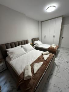 a bedroom with two beds with towels on them at Sunset Apartment in Orikum