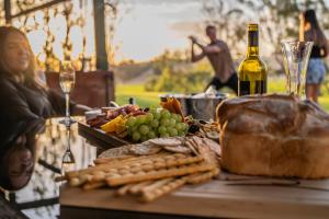 a table with a bottle of wine and a plate of food at Norm's Vineyard Retreat in Lyndoch