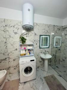 a bathroom with a washing machine and a sink at Sunset Apartment in Orikum +42 photos